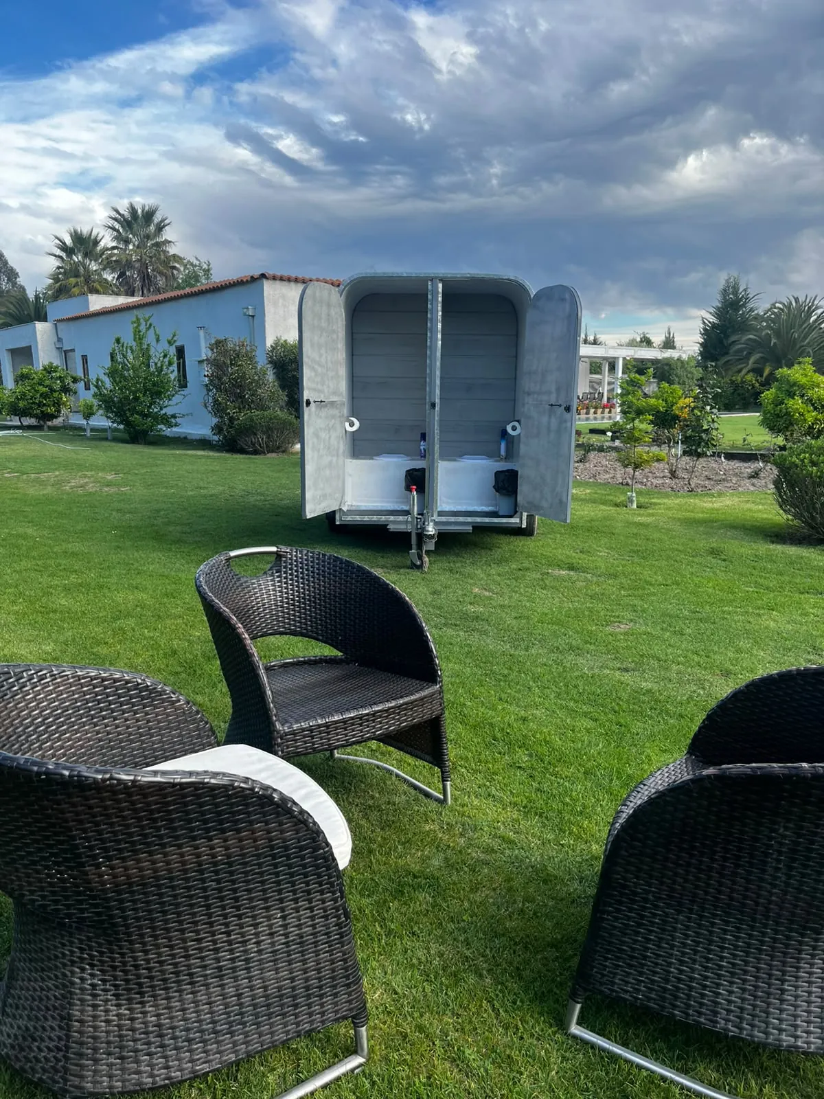 Carro cuádruple instalado en un jardín con dos cabinas abiertas al fondo